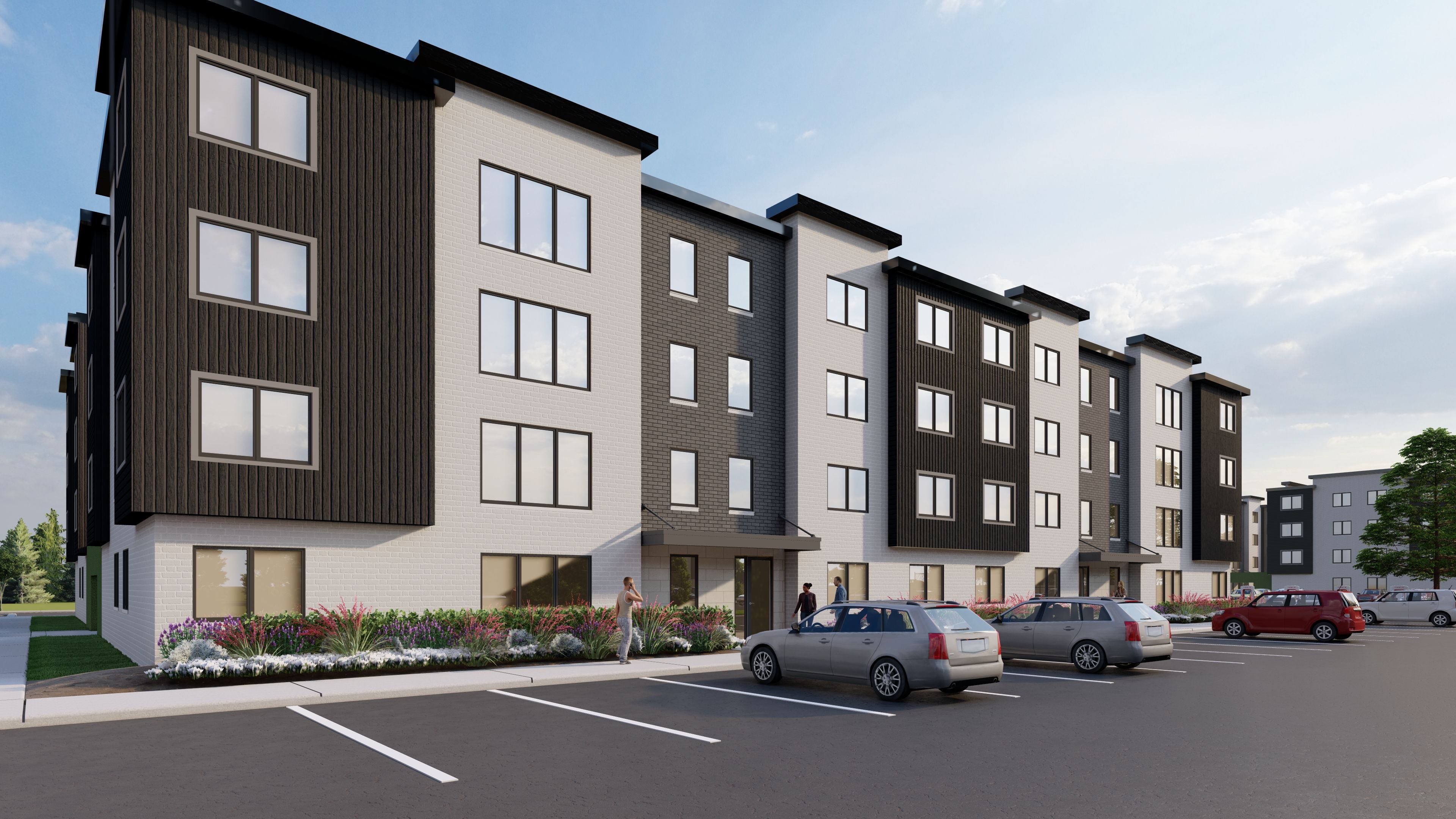 A row of modern apartment buildings with cars parked in front.